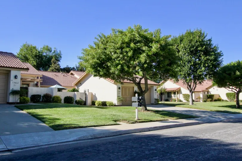A sunny day in Oaks North villas has a number 17647 and trees and bushes