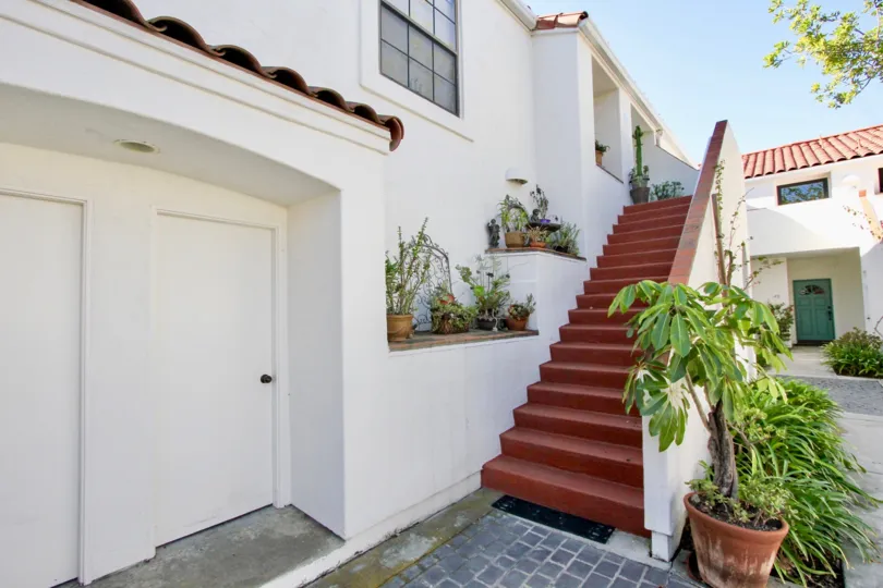 A sunny day in Palazzo Bernardo, A villa has flower pots in steps and has a bush in ground