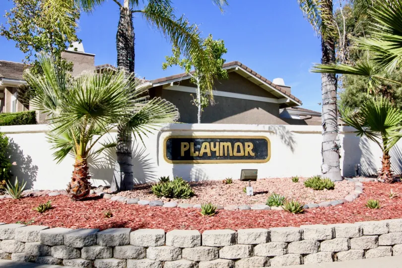 Gold and black sign on white wall at Playmor in Rancho Bernardo California