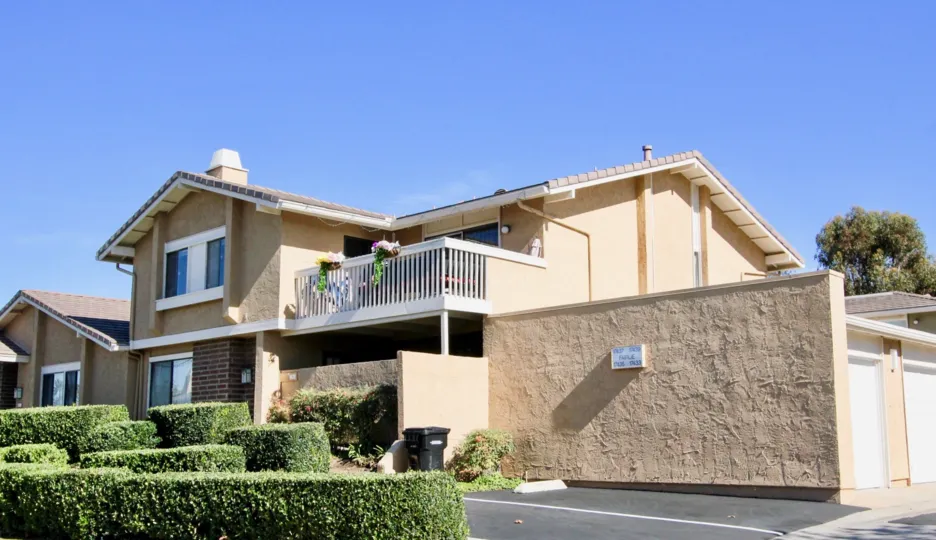 A sunny day in Playmor, villa's has flower pots in balcony and with bushes in ground