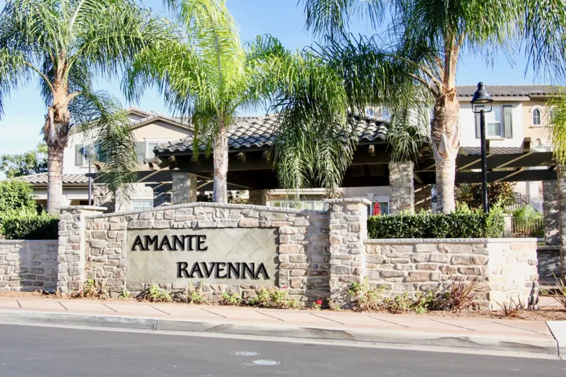 Two story residential units with stone sign near street at Ravenna in Rancho Bernardo CA