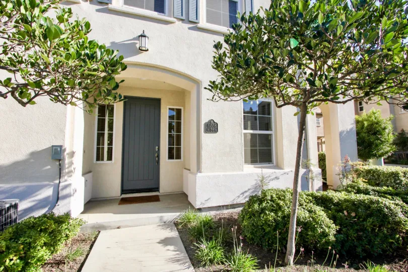 A front view of San Moritz in Rancho Bernardo city has plants and trees