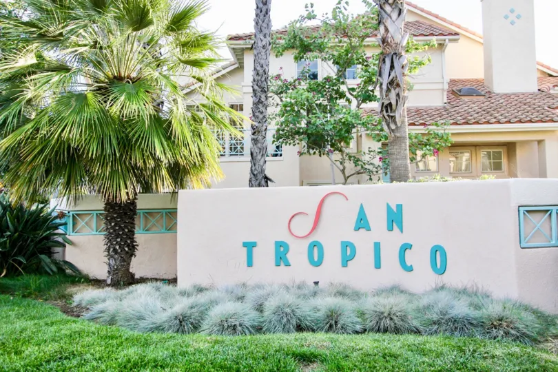 Blue and red sign on a pink wall at San Tropico in Rancho Bernardo CA