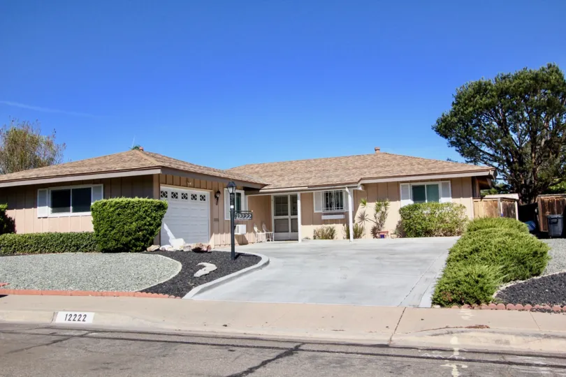 Single story home with white garage door and plants at Seven Oaks in Rancho Bernardo CA