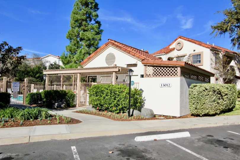 A villa in Stony Brook has a number 13012 with tall trees and plants