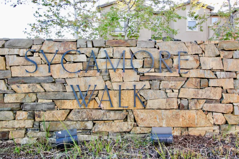 Black iron sign on stone wall near residence at Sycamore Walk in Rancho Bernardo CA