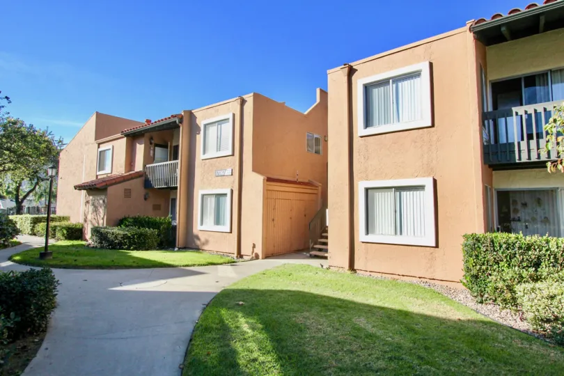 Exterior view of multilevel apartments with grass and pathways in community of waterbridge