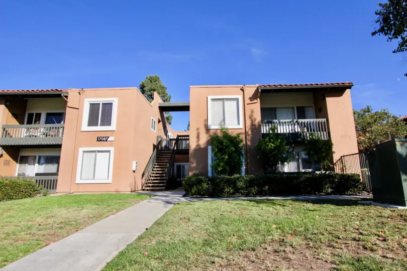 Two story pink buildings with lush green grass at Water Bridge in Rancho Bernardo CA