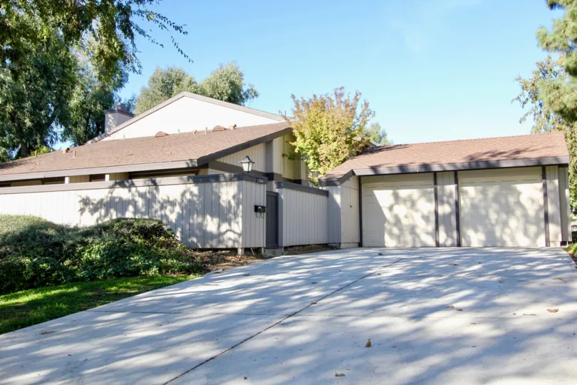 The villa in Westwood Townhomes has trees and bushes at the side of the pathway