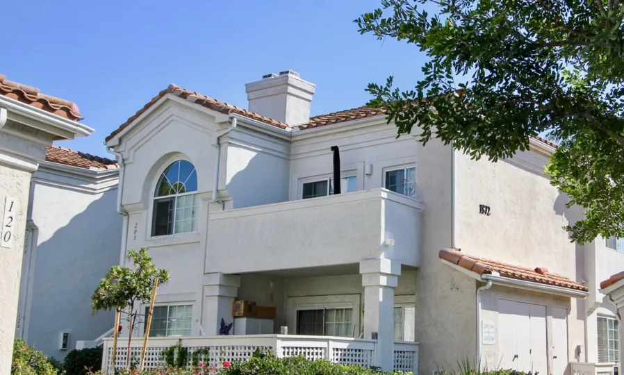 View of a two story home in Ambiance community of porch and balcony