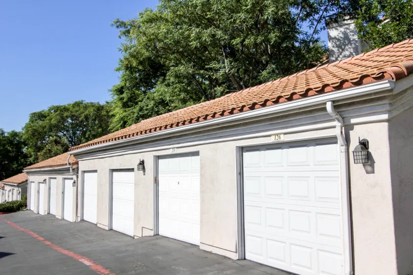 Single car garage units on a gentle sloping back lane with spanish inspired roofs in San Marcos