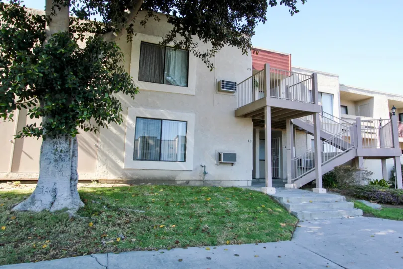 An exterior view of the units at Autumn Heights apartments with large sliding windows, an exterior stair case, and private balconies.