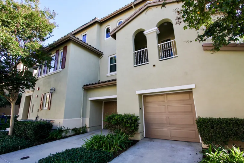 A three-storey residence with brown garage doors and olive walls in Calico Bluffs neighborhood