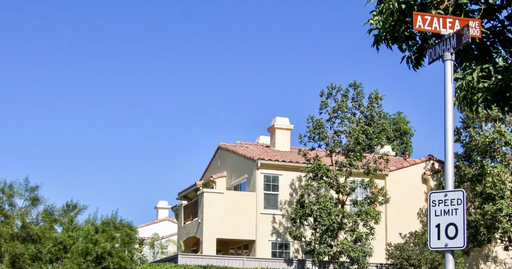 A traditional two-storey residence with a sign post in the Campana community.