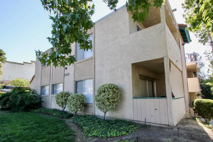 The outside of a two story apartment building on a sunny day in San Marcos, CA.