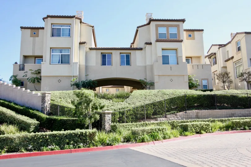 THE BUILDING IN THE CORONADO RANCH WITH THE GRASSES, STEEL WALL, PATHWAY, BALCONIS, PLANTS