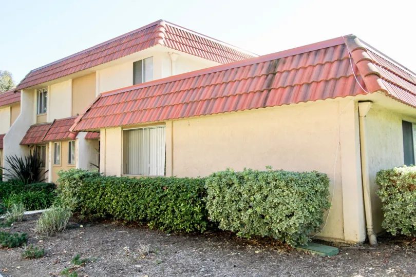 A large building with windows and red roofed shingled in Lake Park Terrace community.