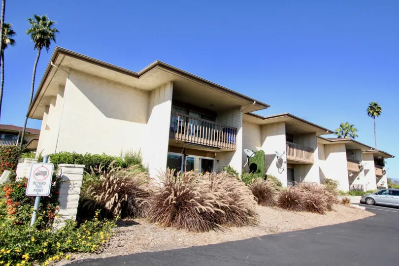 Sunny sky with apartments and a tree and bushes in the Lake San Marcos III Community in San Marcos, CA.