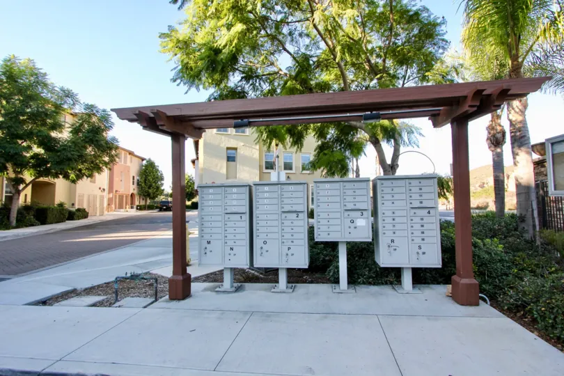 Gray mail boxes with black identifying letters in Larkspur Creek at San Marcos CA