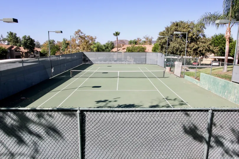 Sunny sky and a tennis court with fence in the Mission Park Community in San Marcos, CA.