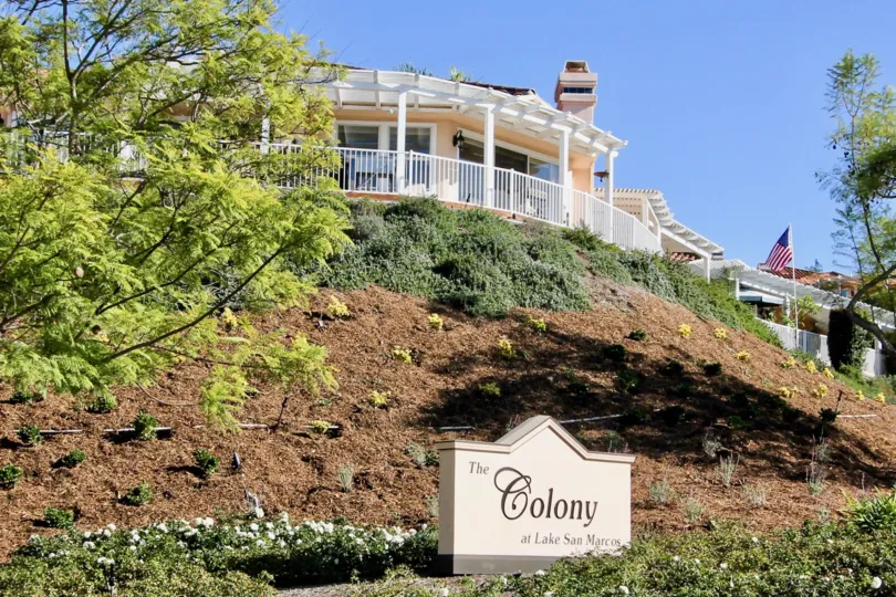 THE BUILDING IN THE COLONY WITH THE NATIONAL FLAG, TREES, PLANTS