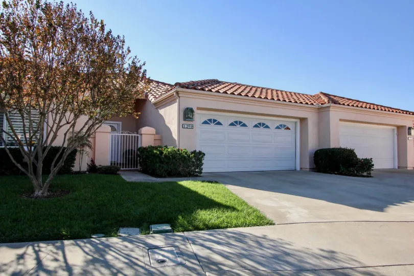 Single story pink homes with white garages inside The Colony in San Marcos CA