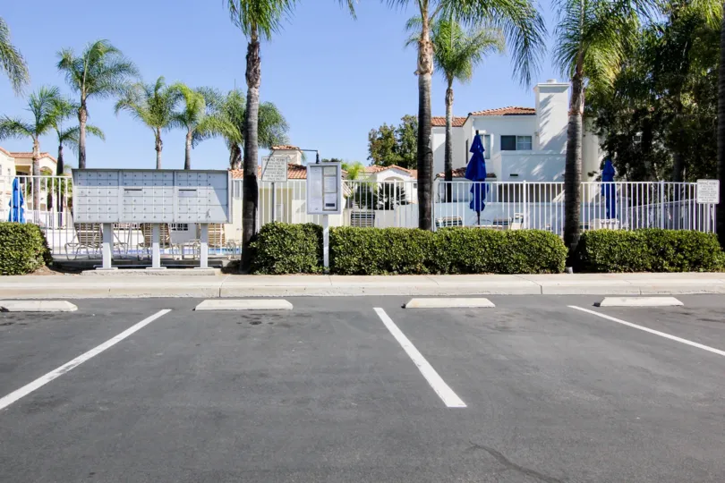 A sunny day in the area of Villa Aspara, outside, palm tree, pool, fence, umbrella, parking lot