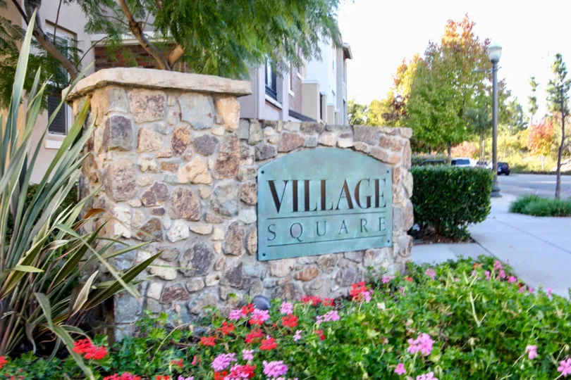 At the entrance, A wall with Village Square and under of the wall with beautiful flowers