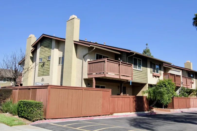 Two story green and brown housing with red railing inside WEstlake Ranch at San Marcos CA