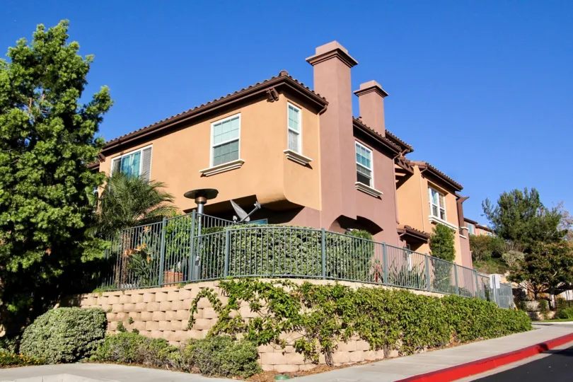 A sunny day in the area of Westridge, outside, condo, balcony, tree, chimney, fence