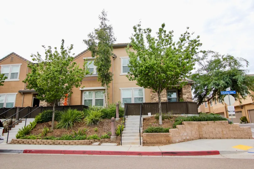A frontal view of an apartment complex and it's neat landscaping located in Aubrey Glen.