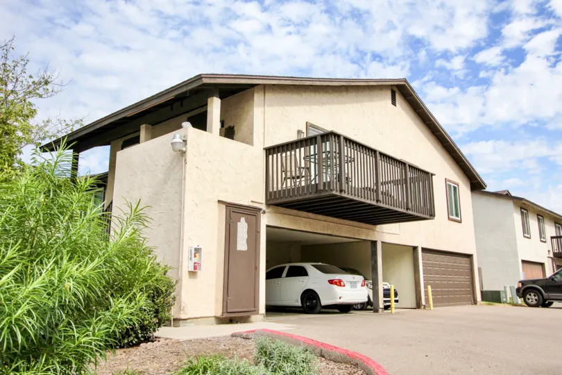 Carefree East, Santee, CA.  A large brown houe with a 3 car garage, full deck, columns, and green landscaping.
