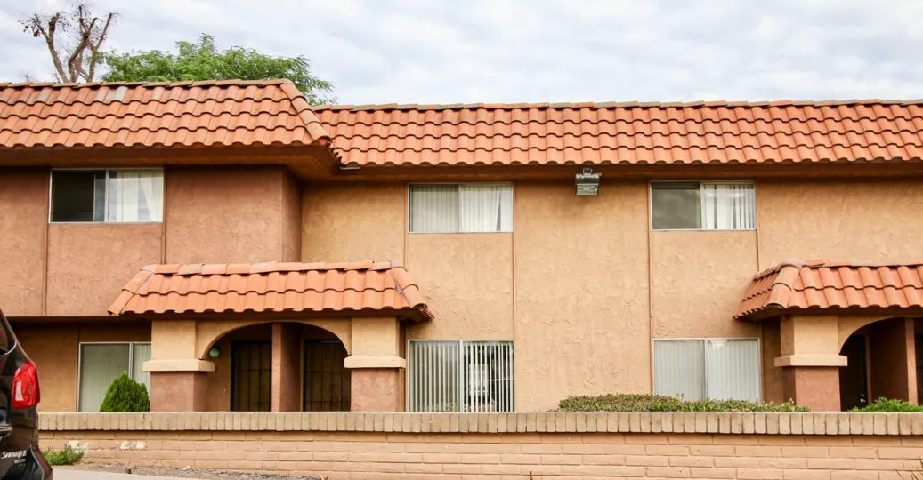 A sunny day in the area of Carlton Country Club Villas, brick wall, doors, windows, roof, trees