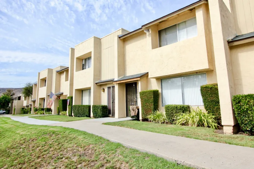 A sunny day in the area of Corsican Villas, Condo, gated doors, bushes, sidewalk