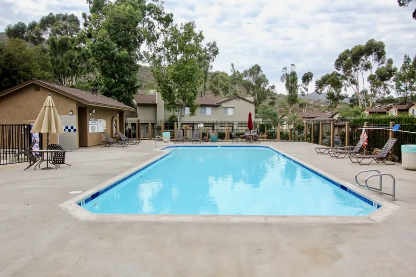 A sunny day poolside in the Highland Trails area, beach chairs, umbrellas, trees