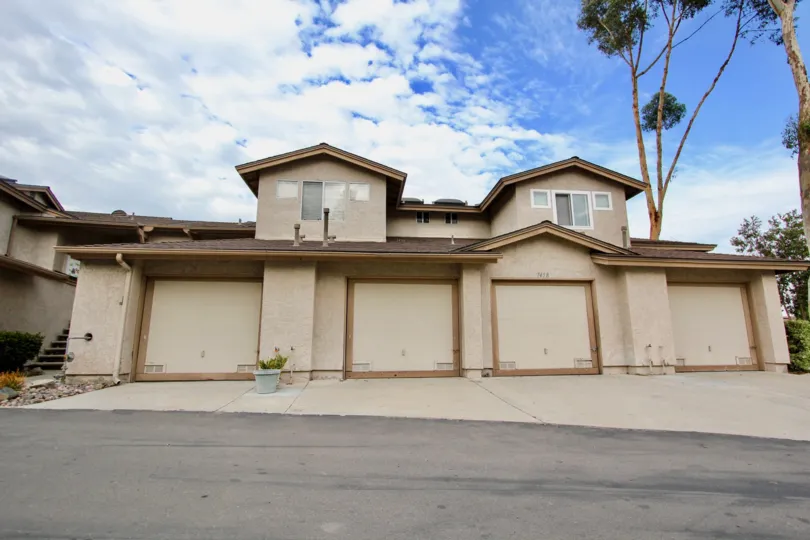 Tan two story house with four garages and cement driveway, house number 7458 in Highland Trails, Santee, CA