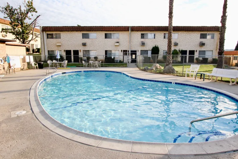 The pool area during the day in Horizon Village with pool hair and palm trees in Santee California