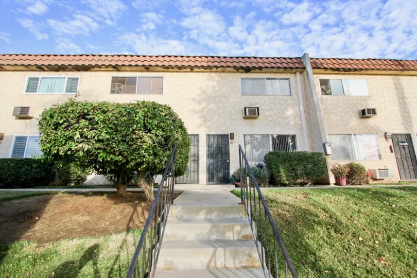 Walk up the steps to Horizon Village in Santee California and see the beautiful landscapes for yourself! There is green shrubbery and grass all around.