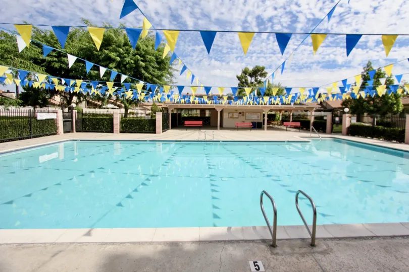 A pool with benches in the background and flags for decoration in Magnolia Meadows