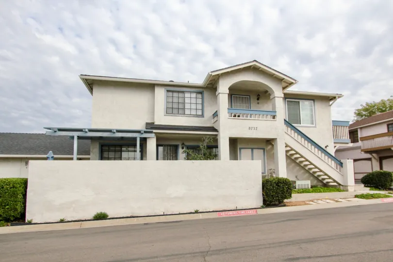 A home with white concrete walls in the Mission Martinique community of Santee California is seen on a cloud day.