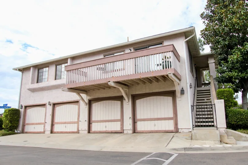 A view of four garage doors and a balcony on the second floor in the Mission Martinique neighborhood in Santee, California