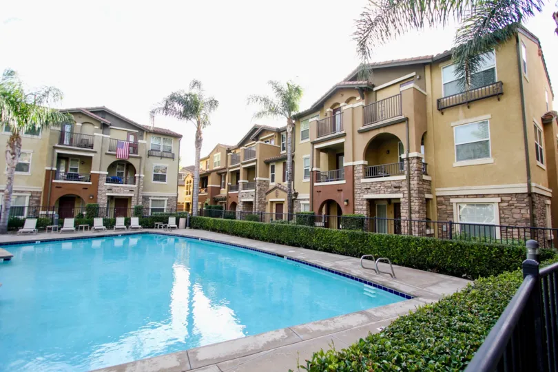 beautiful in ground clear blue pool outside yellow and brick homes in the community of Morningside in Santee, California