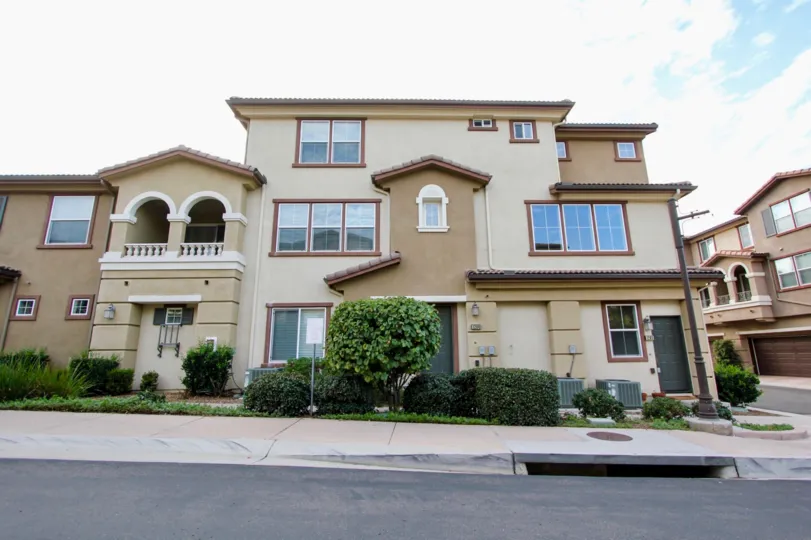Three story building with a large green tree near a street in Northstar at santee CA