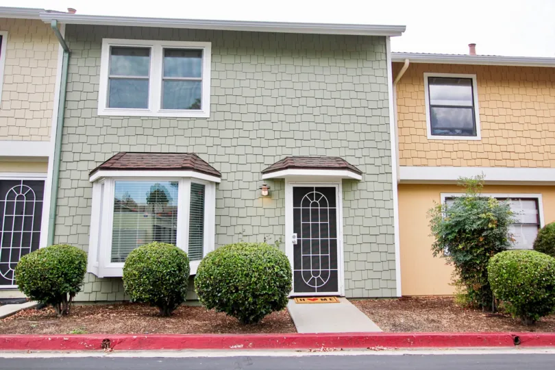A sunny day in the area of Pepperhill Townhomes, door, window, entrance, bushes