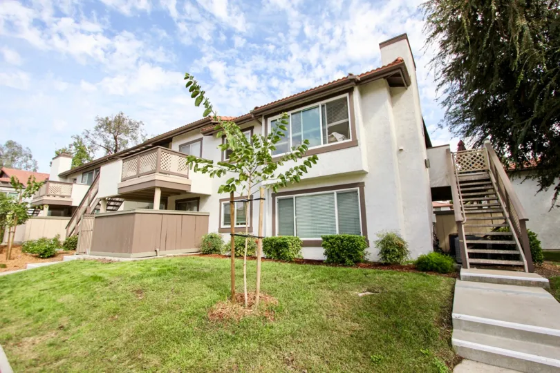 lawn view of two story complex showing stairs and windows of building