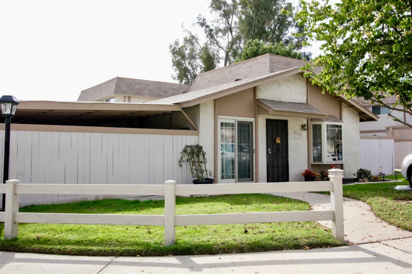 A sunny day in the area of Santana Ranch, wooden fence, condo, gated door, car, walkway