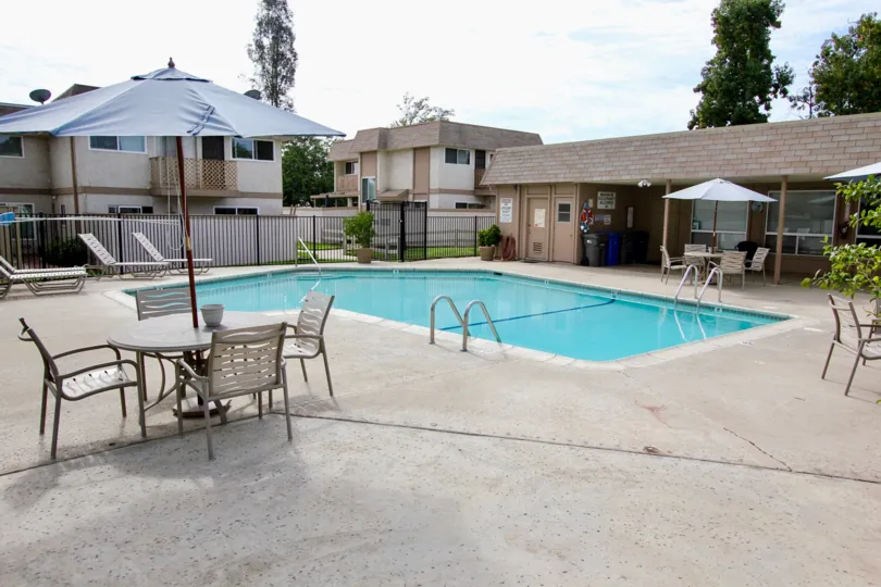 A shared pool area for an apartment complex in Santee, California featuring a clubhouse and concrete patio