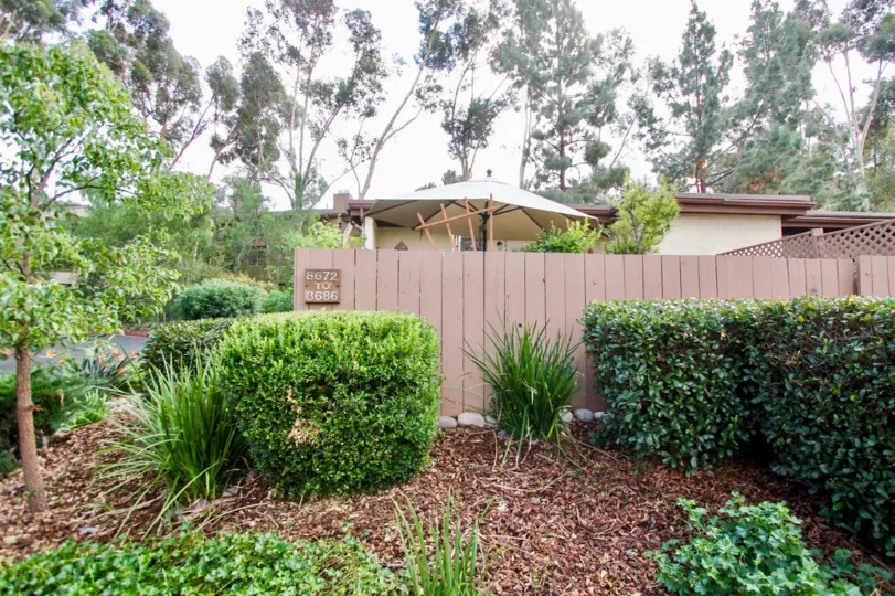 Large green bushes outside of a fence near the Sunset Greens in Santee CA