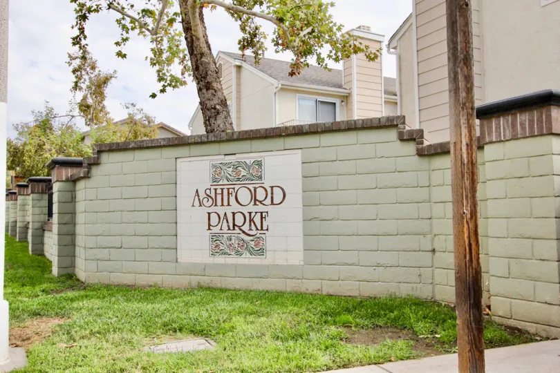 Wall with a sign and tree in the Ashford Park Community in Spring Valley, CA.