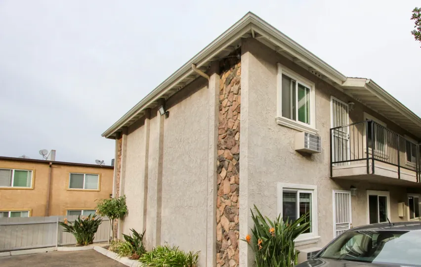 A side view of a property in Buena Vista Condominiums with a car